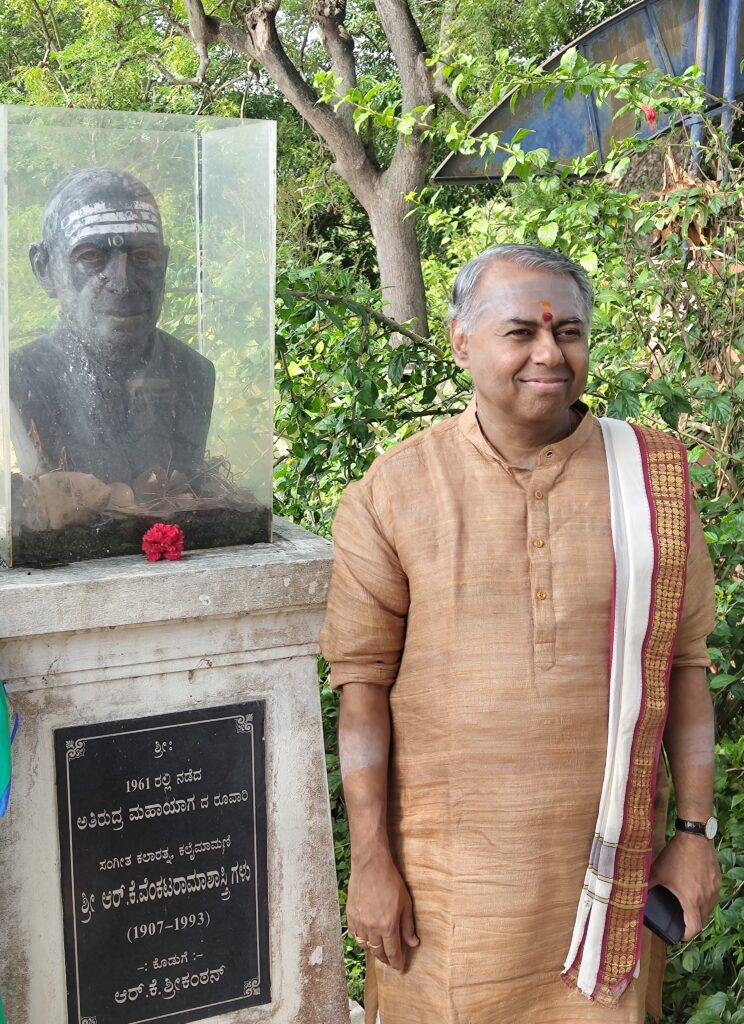 Sangita Kalanidhi Vidvan R K Shriramkumar beside a memorial honoring his musical lineage